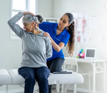 Physiotherapist helping a client with shoulder and back mobility (indicative image)