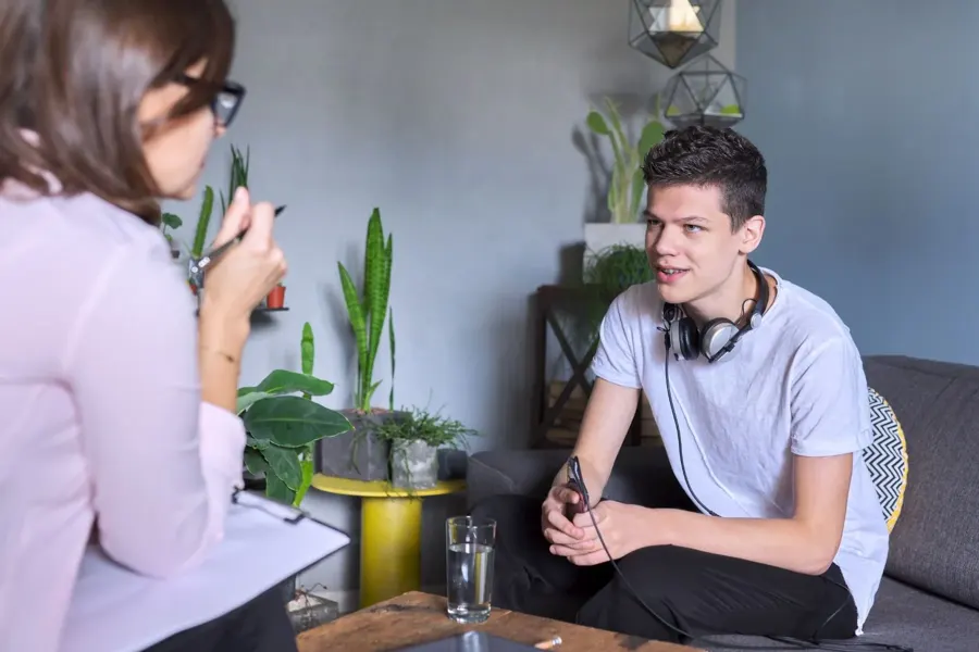 Psychologist talking with a young man in a relaxed home setting